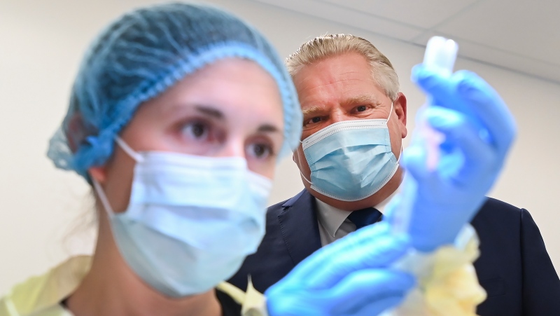 Ontario Premier Doug Ford watches a health-care worker prepare a dose of the Pfizer-BioNTech COVID-19 vaccine at a UHN vaccine clinic in Toronto on Thursday, January 7, 2021. THE CANADIAN PRESS/Nathan Denette
