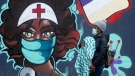 A woman walks past a mural in downtown Ottawa, Thursday January 14, 2021 in Ottawa. (Adrian Wyld/THE CANADIAN PRESS)