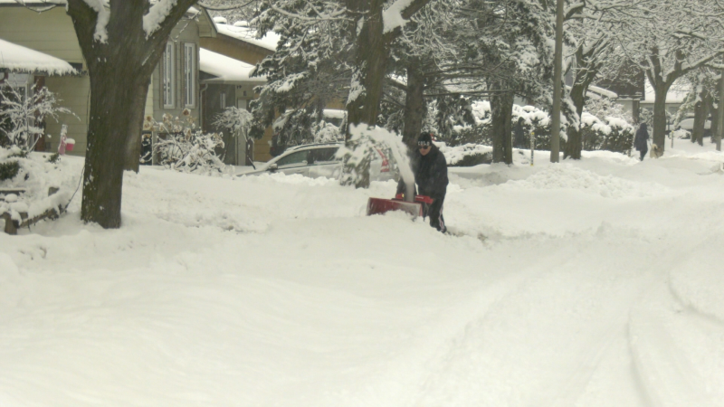 A man uses a snow blower to clear snow after a significant snowfall in Ottawa Saturday, Jan. 16, 2021. (Shaun Vardon / CTV News Ottawa)