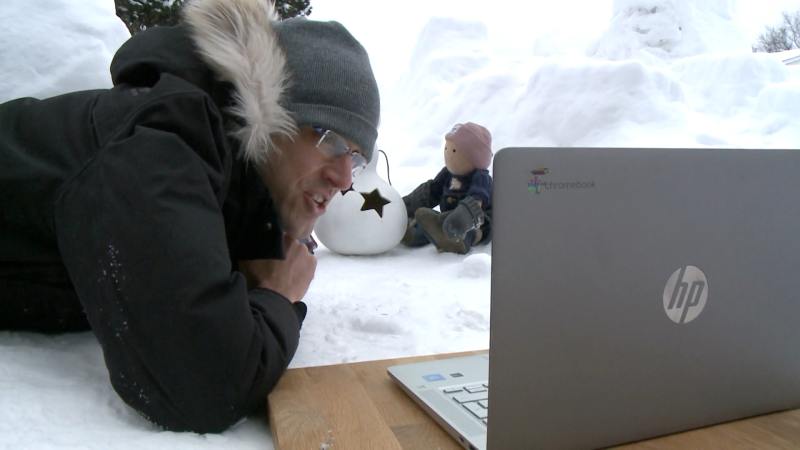 Patrick Revie teaches a virtual class with a snow fort on his front lawn as the backdrop. (Jim O'Grady / CTV News Ottawa)