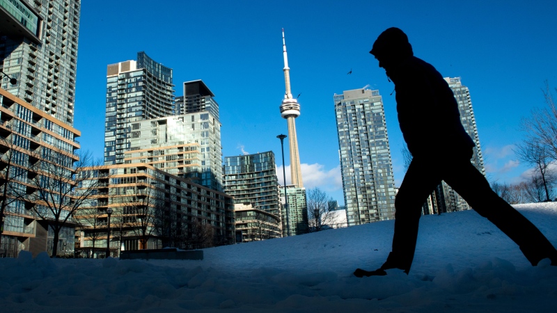 FILE- Condo towers dot the Toronto skyline as a pedestrian makes his way through the COVID-19 restricted winter landscape on Thursday January 28, 2021. CMHC says that rental vacancies are up in Canada’s largest cities with rents rising too. THE CANADIAN PRESS/Frank Gunn