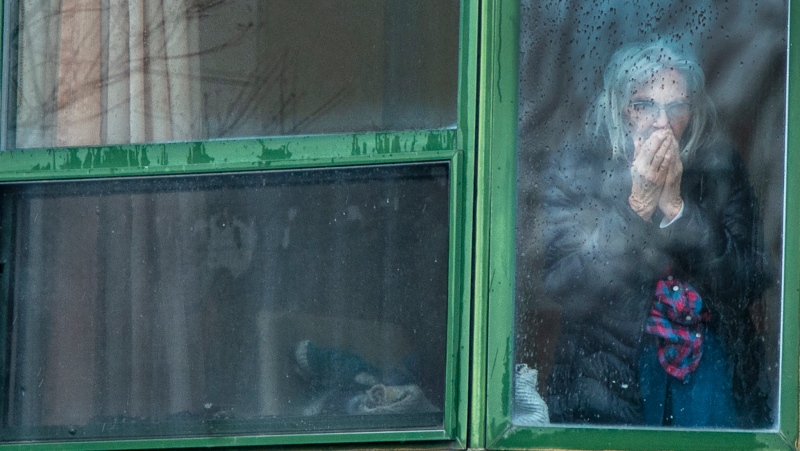 A resident looks out her window from the Herron seniors residence Monday April 13, 2020 in Dorval near Montreal's Trudeau airport. Thirty -one residents are confirmed to have died in the past month.THE CANADIAN PRESS/Ryan Remiorz