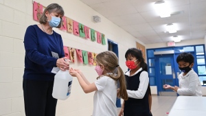FILE - Children sanitize their hands while physical distancing after getting their pictures taken at picture day at St. Barnabas Catholic School during the COVID-19 pandemic in Scarborough, Ont., on Tuesday, October 27, 2020. THE CANADIAN PRESS/Nathan Denette