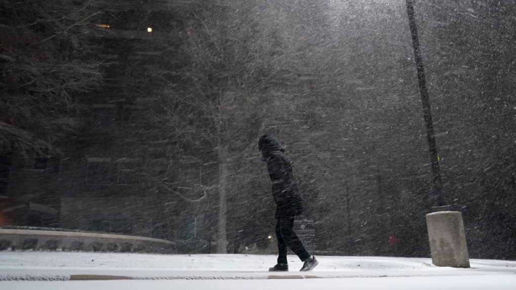 A woman walks through falling snow in San Antonio