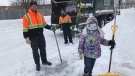 City of London waste collectors Dillon, left, and Justin, right, were spotted by CTV News helping senior Briony O’Leary dig out along Osgoode Drive in London, Ont. on Tuesday, Feb. 16, 2021. (Sean Irvine / CTV News)