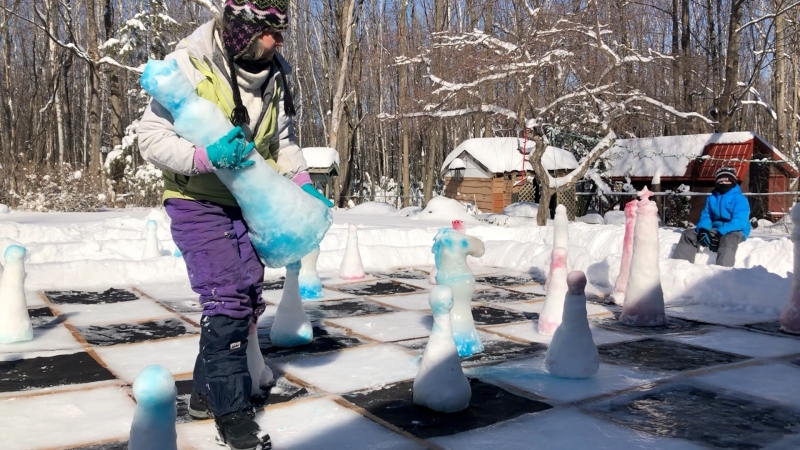 Vicki Carr and her grandson Ethan playing a game of frozen life-sized chess in their backyard. (Dave Charbonneau/CTV News Ottawa)