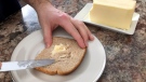 Trying to spread room temperature butter onto a piece of toast. (Dave Charbonneau / CTV News Ottawa)