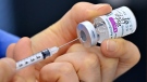 A nurse fills a syringe with the AstraZeneca vaccine. 