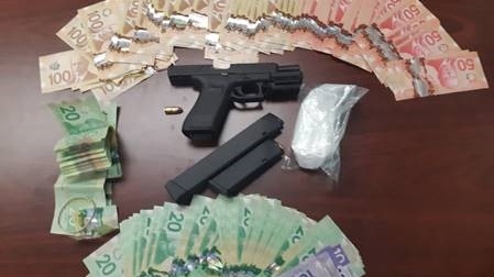 A loaded Glock semi-automatic hand gun, 98 grams of suspected cocaine and $10,000 in cash was seized from a traffic violation on Friday, February 27, 2021 (Source: Sarnia Police, Community Patrol Branch - D Platoon)