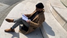 Ryan Antooa looks at his poetry book sharing his mental health journey (Jessica Smith / CTV News Kitchener)