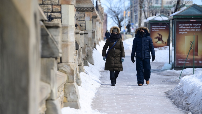 A couple of people make their way along Wellington Street in Ottawa Friday, March 5, 2021. (Sean Kilpatrick/THE CANADIAN PRESS)