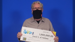 David Schnurr, 61, of Nottawasaga, Ont. hold his big cheque after winning $1 million with Lotto Max in the Feb. 26, 2021 draw. (OLG)