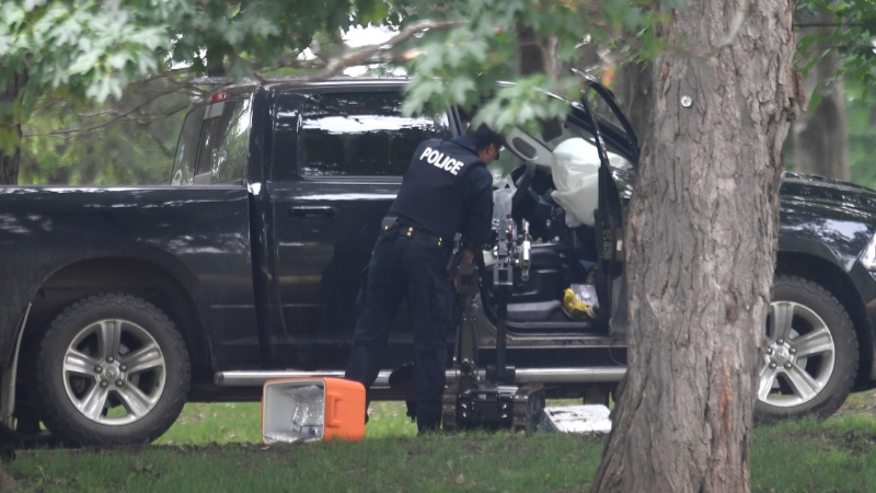 A police officer examines a pickup truck inside the grounds of Rideau Hall in Ottawa on Thursday, July 2, 2020. THE CANADIAN PRESS/Adrian Wyld
