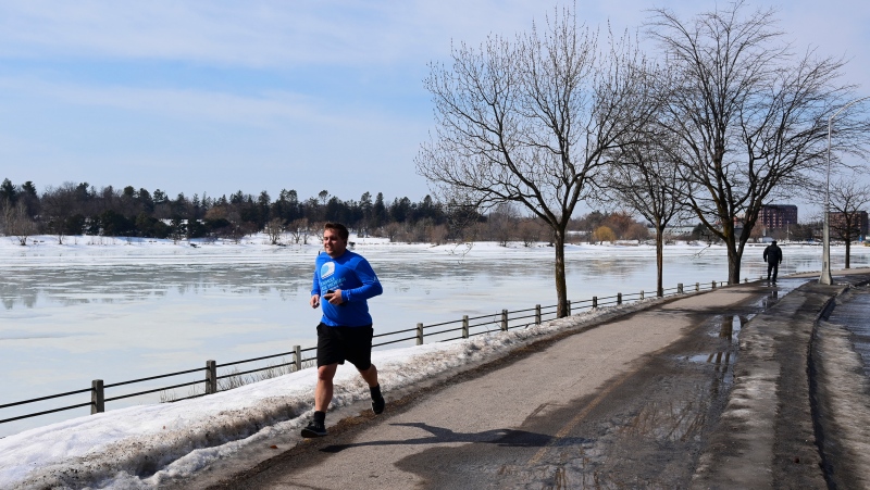 A runner makes their way along the edge of Dow's Lake as warmer temperatures hit Ottawa Thursday, March 11, 2021. (Sean Kilpatrick/THE CANADIAN PRESS)