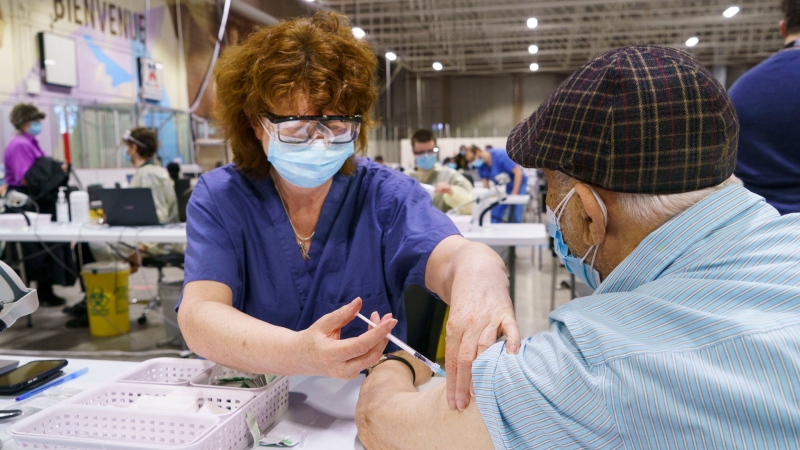 FILE- A senior citizen receives a first dose of COVID-19 vaccine at a vaccination clinic in a hockey arena in Montreal, on Wednesday, March 10, 2021. THE CANADIAN PRESS/Paul Chiasson