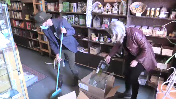 Lyndon Horsfall and Mary Beechie, owners of Mystic Bookshop in London, Ont. clean up after break-in - Sunday, March 21, 2021 (Brent Lale / CTV News)