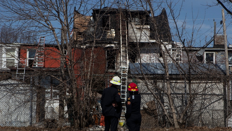Members of the Fire Department inspect the ruins of a house after it was destroyed by a fire in Oshawa, Ontario on Monday March 22, 2021. Friends of an Oshawa family said they feared for the worst Monday as four people remained unaccounted for following a fire that tore through several rowhouses. THE CANADIAN PRESS/Chris Young