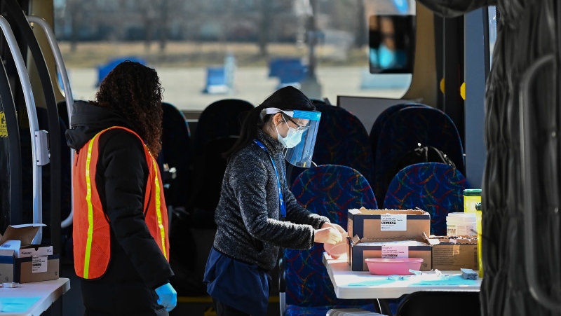 Health-care workers inside the vaccine storage bus make last minute preparations as they get ready for patients at a drive-thru COVID-19 mass vaccination site at Canada's Wonderland during the COVID-19 pandemic in Vaughan, Ont., on Monday, March 29, 2021. THE CANADIAN PRESS/Nathan Denette