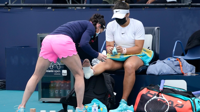 Bianca Andreescu of Canada has her foot taped after she fell on the court during her finals match against Ashleigh Barty of Australia at the Miami Open tennis tournament, Saturday, April 3, 2021, in Miami Gardens, Fla. Barty won 6-3, 4-0, as Andreescu retired due to injury. (AP Photo/Lynne Sladky)
