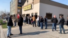 People hold signs outside a restaurant that is remaining open to in-person dining in Leamington, Ont., on Tuesday, April 6, 2021. (Bob Bellacicco / CTV Windsor)
