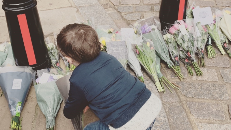 Four-year-old Matthew McEniry lays flowers at the entrance road to Windsor Castle in Windsor, England on Friday, April 9, 2021. (Source: Caitlin McEniry)