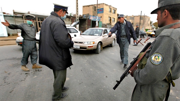 An Afghan police officer orders a driver to stop at a roadside checkpoint in Kabul, Afghanistan, on Saturday, Nov. 7, 2009. Afghanistan's Defense Ministry said a NATO airstrike mistakenly hit a joint base, killing four Afghan soldiers and three policemen. (AP / Gemunu Amarasinghe)