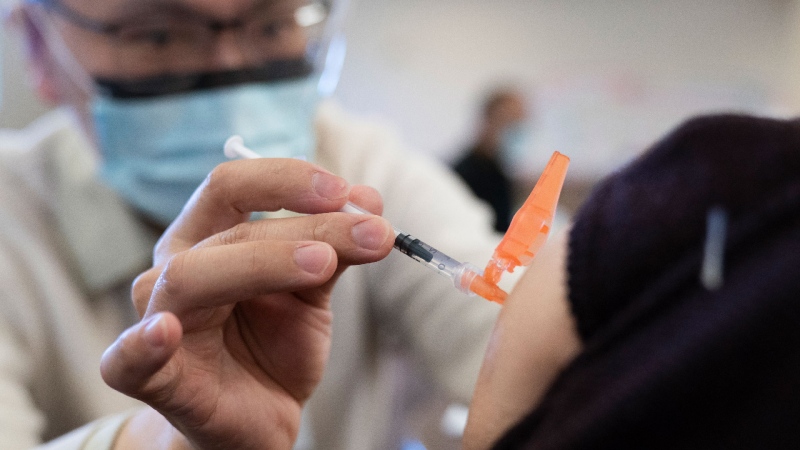 Dr. E. Kwok administers a COVID-19 vaccine to a recipient at a vaccination clinic run by Vancouver Coastal Health, in Richmond, B.C., Saturday, April 10, 2021. THE CANADIAN PRESS/Jonathan Hayward