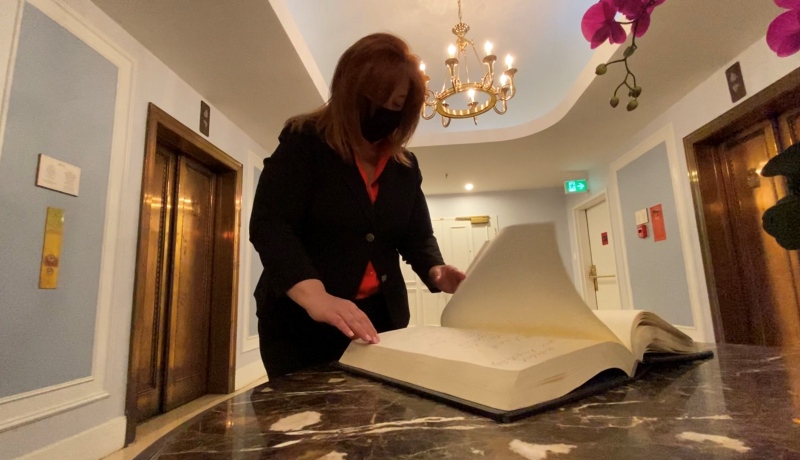 Deneen Perrin, marketing and media director with the Fairmont Chateau Laurier, flips through a guestbook, looking back at celebrities and world leaders she has met throughout her 25 year career. (Tyler Fleming/CTV News Ottawa)