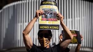 A man holds up a sign with a photograph of Hong Kong media tycoon Jimmy Lai, as people gather for a rally in support of Hong Kong democracy, in Vancouver, B.C., Sunday, Aug. 16, 2020. THE CANADIAN PRESS/Darryl Dyck