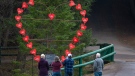 Visitors pay their repects at a memorial honouring the victims of the April 2020 murder rampage in rural Nova Scotia, in Victoria Park in Truro, N.S. on Tuesday, April 13, 2021. The Broken Heart Sculpture was built by Wayne Smith whose stepson Corrie Ellison was killed in the tragedy. THE CANADIAN PRESS/Andrew Vaughan