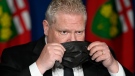 Ontario Premier Doug Ford puts his mask on after speaking at a press conference at Queen's Park, in Toronto, Friday, April 16, 2021. Ontario is extending its stay-at-home order to six weeks, restricting interprovincial travel and limiting outdoor gatherings in an effort to fight a losing battle with COVID-19. THE CANADIAN PRESS/Frank Gunn