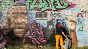 Daryel Simmons reaches up to touch the names of Sandra Bland and Breonna Taylor as she came to a George Floyd memorial mural after learning of the guilty verdict on all counts in the murder trial of former Minneapolis Officer Derek Chauvin in the death of George Floyd on Tuesday, April 20, 2021, in Houston. (Brett Coomer/Houston Chronicle via AP)