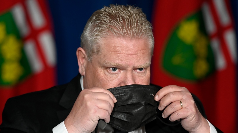 Ontario Premier Doug Ford puts his mask on after speaking at a press conference at Queen's Park, in Toronto, Friday, April 16, 2021. (THE CANADIAN PRESS/Frank Gunn)
