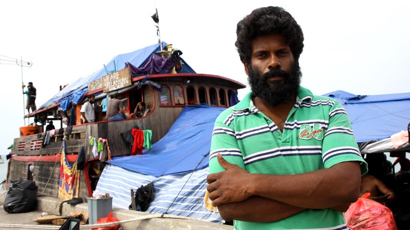 Sanjeev Kuhendrarajah, also known as Alex, stands near the boat used by the immigrants, at Merak Port, Indonesia, in this undated image. (The Australian)