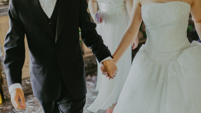 The stock image shows a bride and groom. (Pexels)