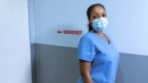 Woman in blue scrub suit wearing white face mask. (Pexels, RODNAE Productions)
