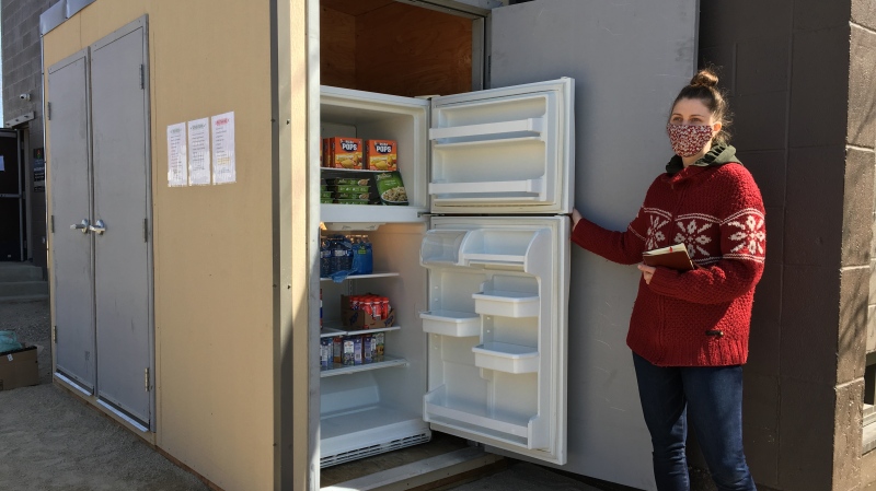 Erica Mthembu stands next to the newly opened 12th Avenue Community Fridge. (Taylor Rattray/CTV News) 