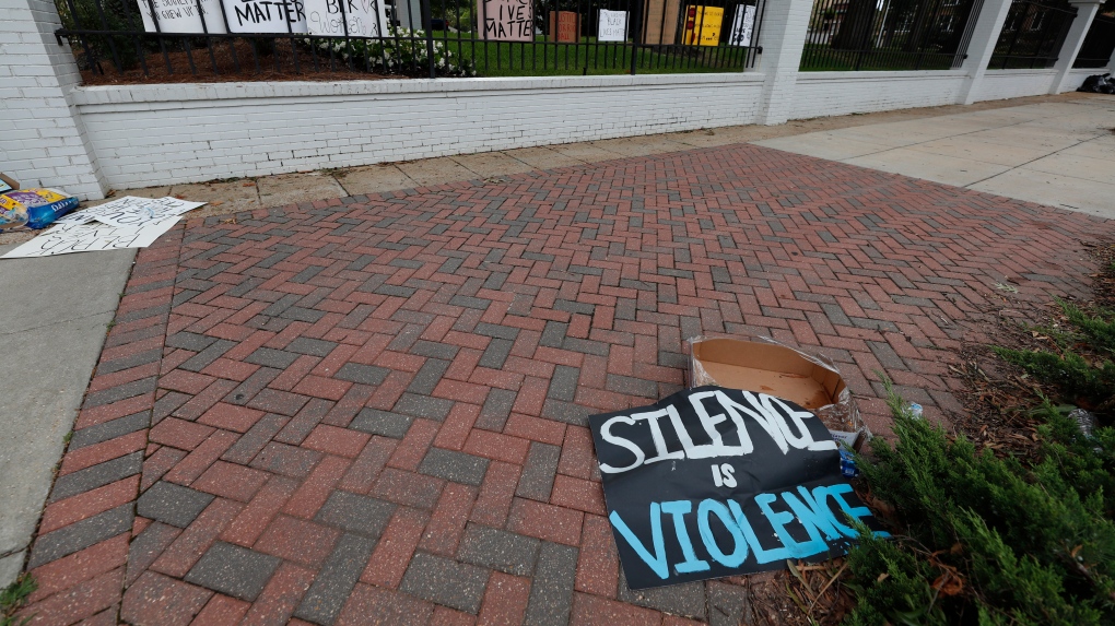 Discarded sign reads 'Silence is Violence'