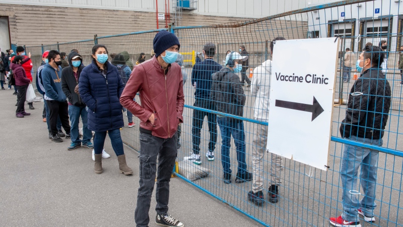 People line up for the COVID-19 vaccination clinic at the Ontario Food Terminal in Toronto on Tuesday May 11, 2021. THE CANADIAN PRESS/Frank Gunn