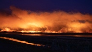 A forest fire burns late into the evening northeast of Prince Albert, Sask., on Monday, May 17, 2021. THE CANADIAN PRESS/Kayle Neis
