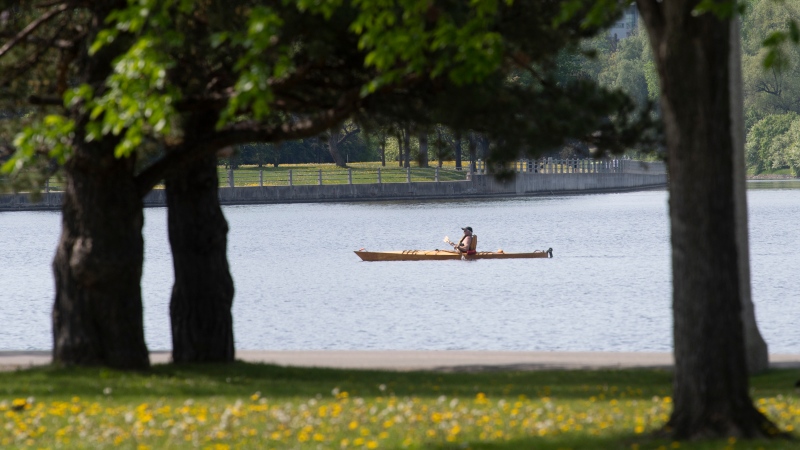 A man paddles across Dow's Lake, Tuesday May 18, 2021 in Ottawa. Summer temperatures were forecast in the region with an expected high of 25C. (Adrian Wyld/THE CANADIAN PRESS)