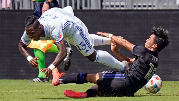 FC Cincinnati midfielder Joseph-Claude Gyau (13) is tripped up by CF Montreal midfielder Joaquin Torres (18) during the second half of an MLS soccer match, Saturday, May 22, 2021, in Fort Lauderdale, Fla. (AP Photo/Wilfredo Lee)