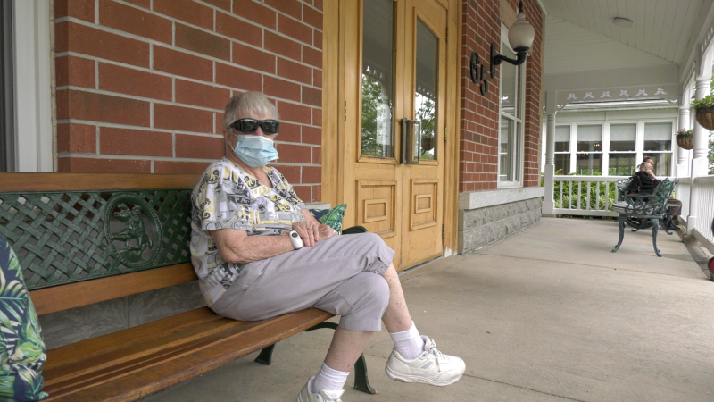 A woman sits outside Champlain Manor in Orillia, Ont. on Tues., May 25, 2021. (Kraig Krause/CTV News)