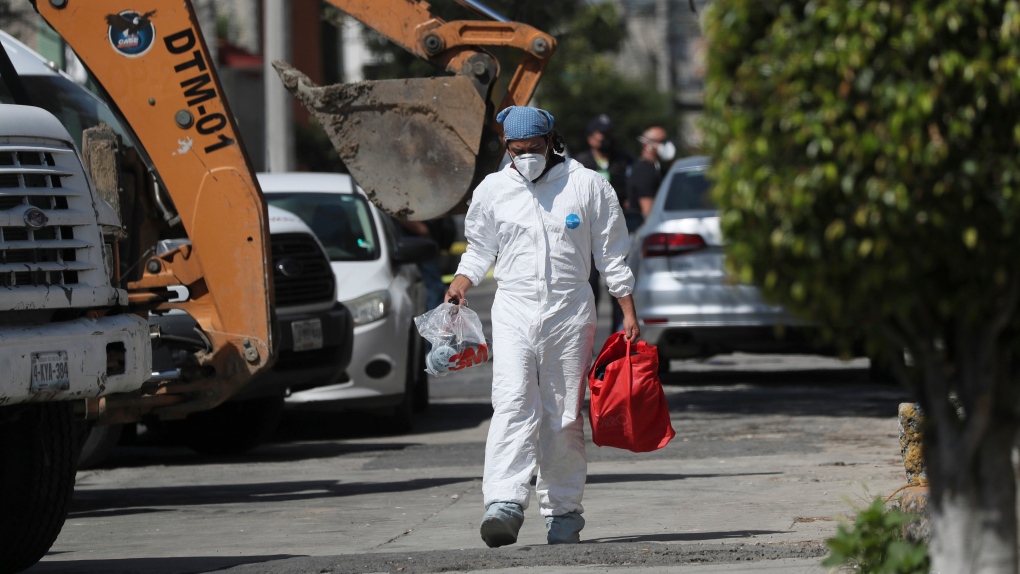 A forensic investigator carries equipment 