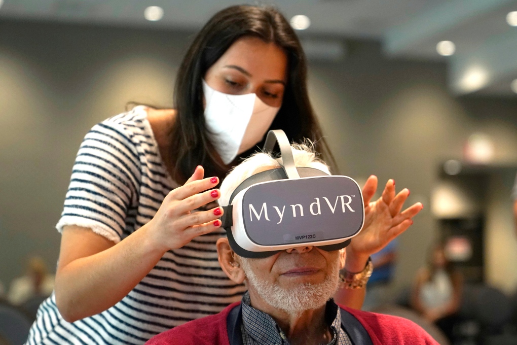 Woman adjusts VR set on senior man