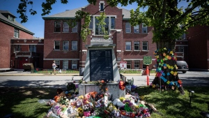 Flowers and cards are left at a makeshift memorial at a monument outside the former Kamloops Indian Residential School, to honour the 215 children whose remains have been discovered buried near the facility, in Kamloops, B.C., on Monday, May 31, 2021. THE CANADIAN PRESS/Darryl Dyck