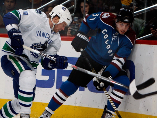 Vancouver Canucks center Ryan Johnson, left, battles for control of the puck with Colorado Avalanche rookie center Ryan O'Reilly in the first period of an NHL hockey game in Denver on Saturday, Nov. 14, 2009. (AP Photo/David Zalubowski)