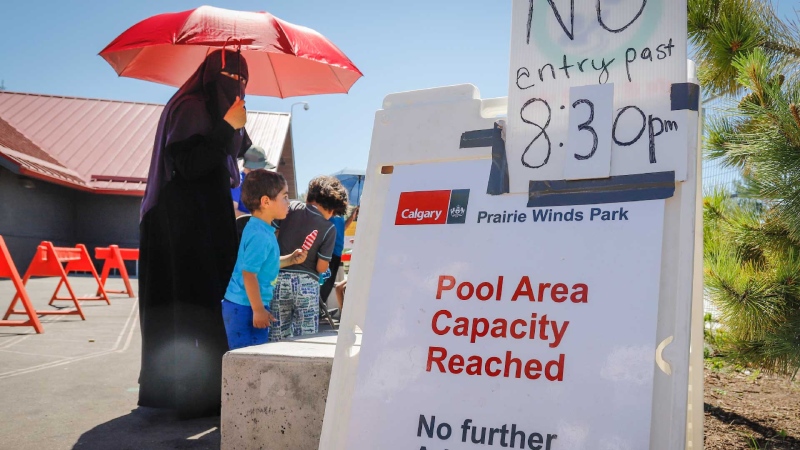 People lineup at a splash park to try and beat the heat in Calgary, Alta., Wednesday, June 30, 2021. (THE CANADIAN PRESS/Jeff McIntosh)