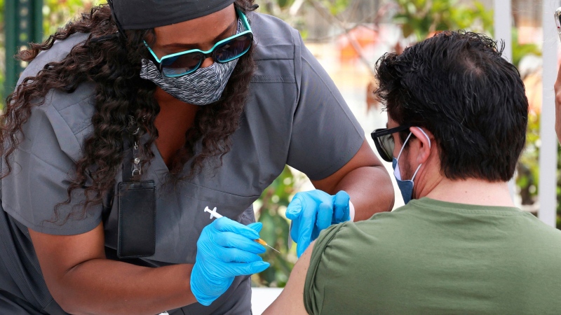 In this June 17, 2021, file photo, an Orange County resident receives the COVID-19 vaccine at the Florida Division of Emergency Management mobile vaccination site at Camping World Stadium in Orlando, Fla. (Joe Burbank/Orlando Sentinel via AP, File) 