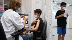 An Israeli youth receives a Pfizer-BioNTech COVID-19 vaccine in the central Israeli city of Rishon LeZion, Sunday, June 6, 2021. (AP Photo/Sebastian Scheiner) 
